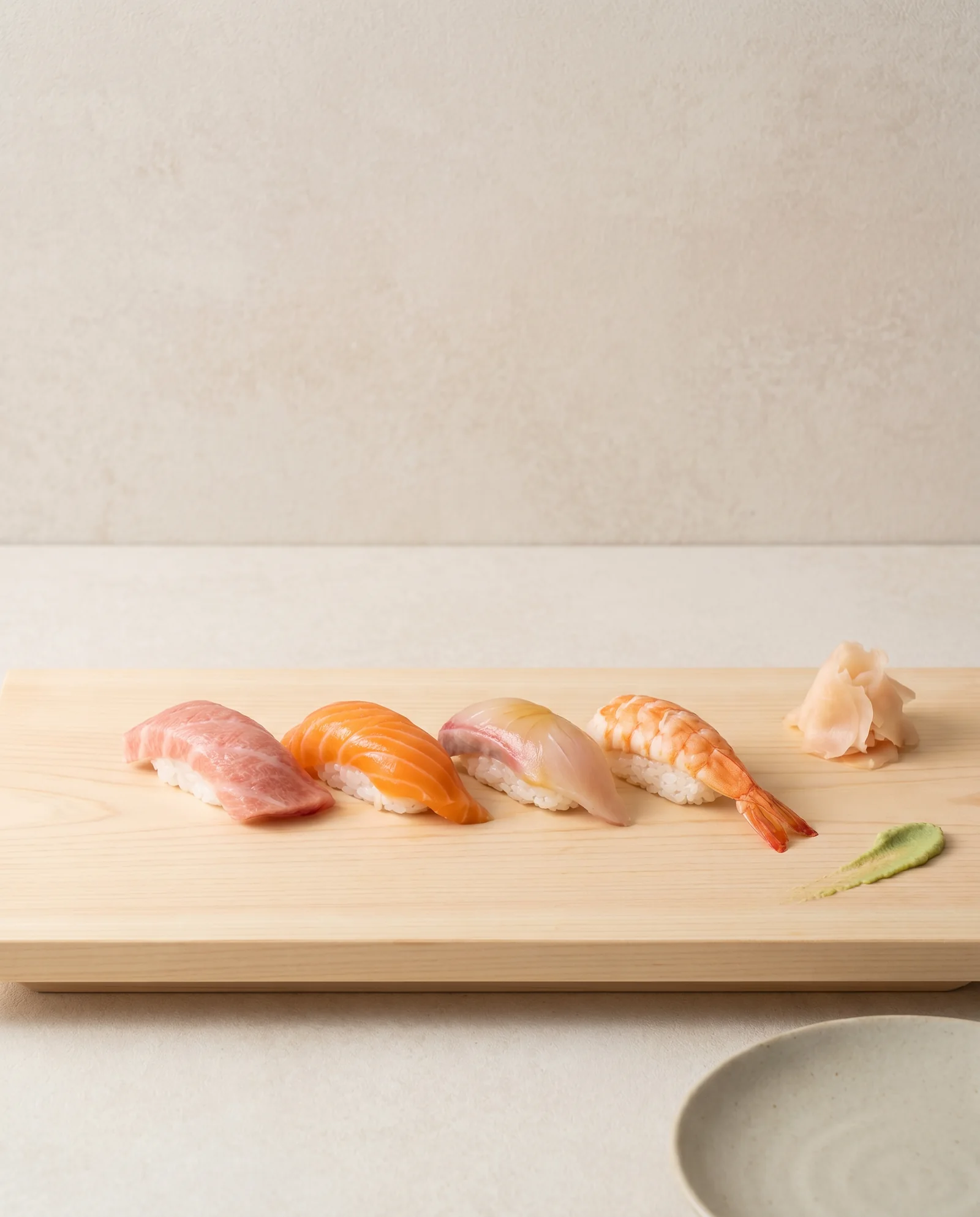 An omakase nigiri selection on a hinoki wood board